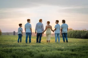 Famille dans un paysage de nature, sur le gazon - enfant parentifié et rôles familiaux - Psychopraticien Paris 9