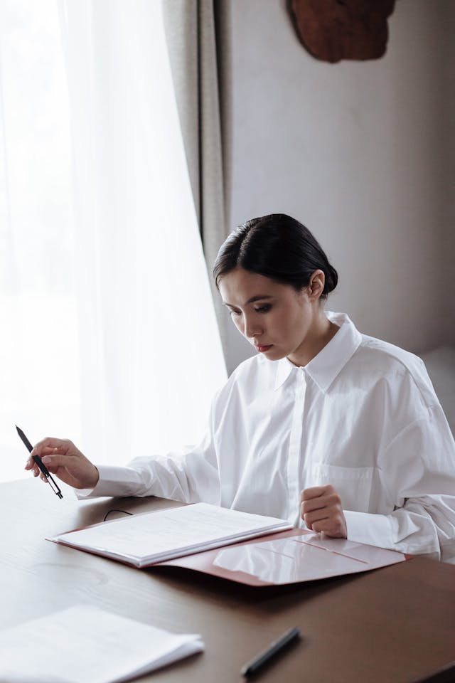 Femme anxieuse devant des papiers, le stylo à la main - phobie administrative - psychothérapie à Paris 9