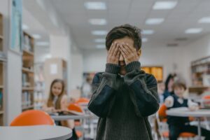 enfant les mains sur le visage - harcèlement scolaire - psychopraticien Paris 9