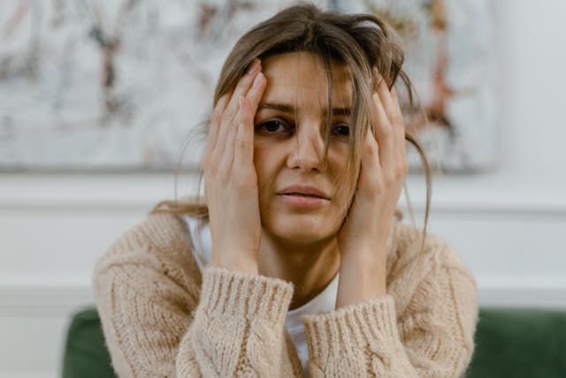 Femme anxieuse en thérapie, le mains sur les tempes et les joues - trouble anxieux généralisé (TAG) - psychothérapie Paris 9