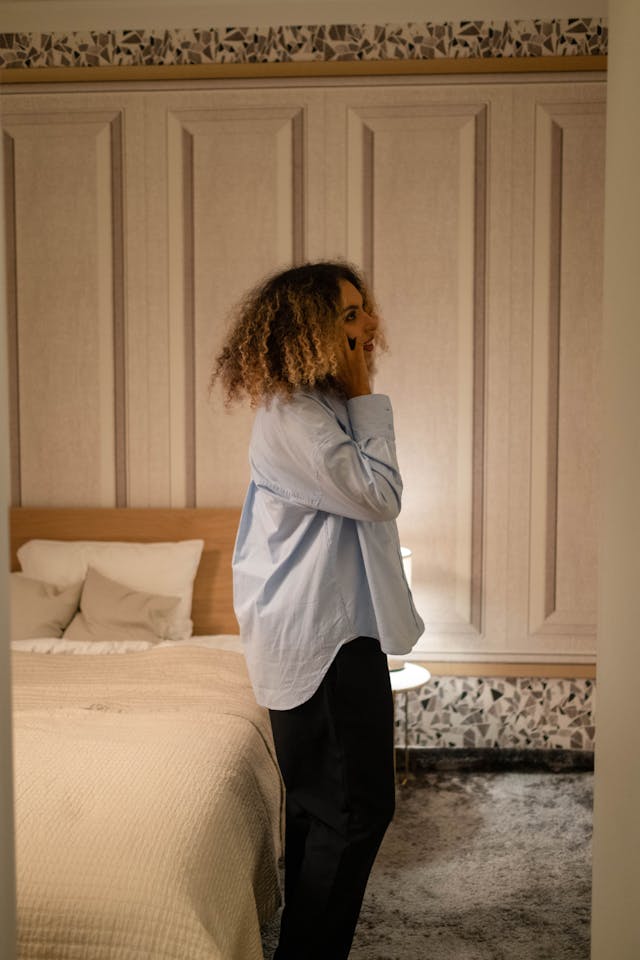 Femme au téléphone, debout dans sa chambre à coucher - dépendance affective - psychothérapie Paris 9