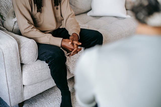 Homme les mains croisées sur le canapé, en thérapie - dépendance affective - psychothérapie Paris 9