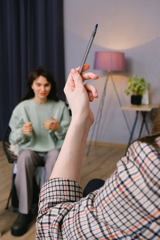 Thérapeute le stylo levé vers le haut, en face d'une patiente - multiplier les thérapeutes - psychothérapie Paris 9