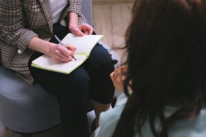 Séance de thérapie où le thérapeute prend des notes, face à sa patiente - thérapie des schémas - psychothérapie Paris 9