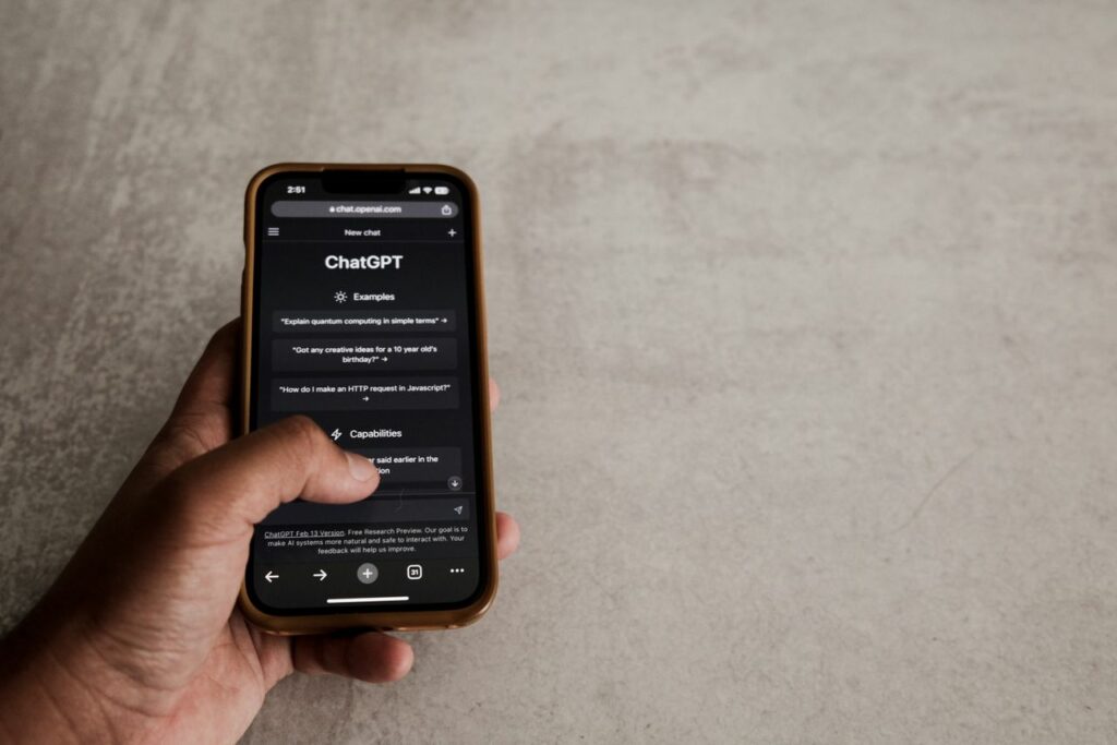 Main qui tapote sur son téléphone sur l'application chatGPT - Psy IA - psychothérapie Paris