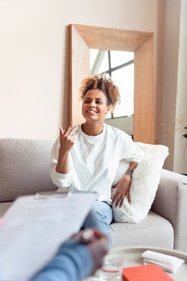 Femme qui s'exprime avec le sourire devant son thérapeute - Thérapie ACT - Psychothérapie Paris 9