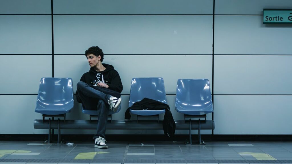 Homme, pensif, assis sur un siège à une station de métro - dysthymie - psychothérapie Paris