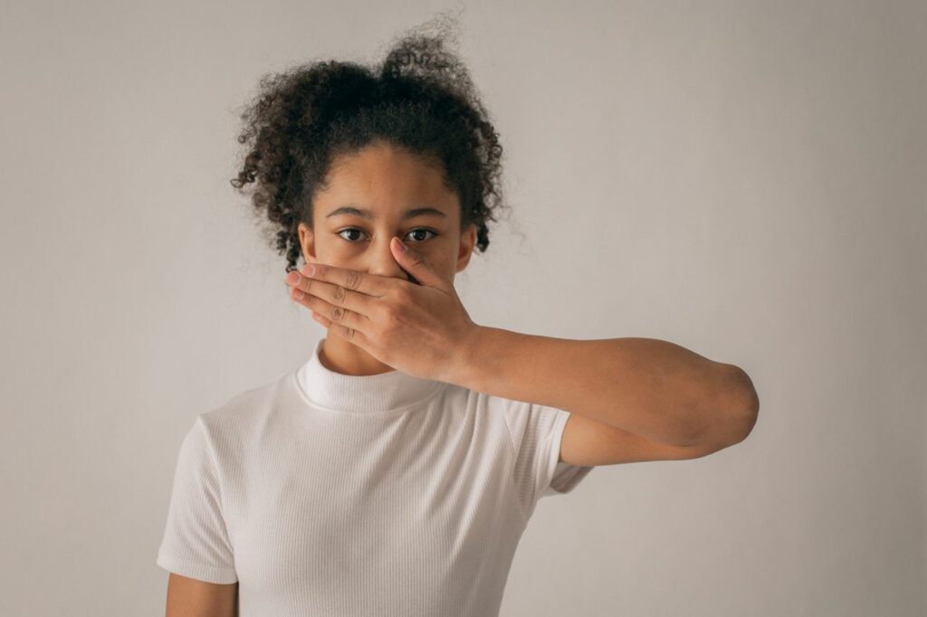 Jeune femme avec la main sur la bouche - honte toxique - psychothérapie Paris