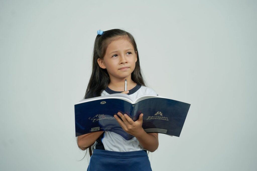 Jeune fille avec son cahier et son stylo à la main, pensive - syndrome de la bonne élève - psychothérapie Paris 9
