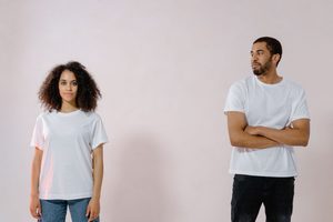 Couple à moins d'un mètre l'un de l'autre. La femme regarde face à elle, neture, l'homme la regarde sur le coté, pensif - TOC relationnel - Psychothérapie Paris 9 et Pantin